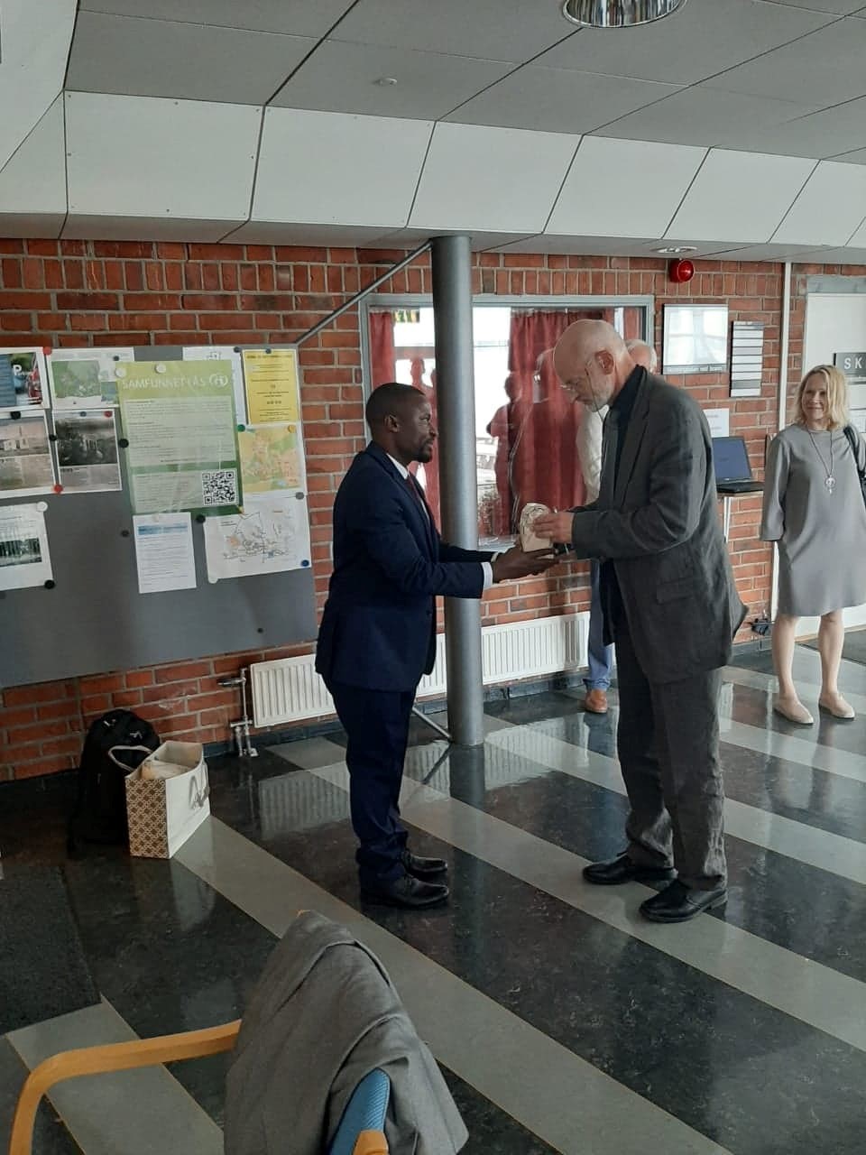 Dr. Nyamoga thanking and handing a small gift to Professor Ola Ericksson for being part of the Evaluation Team