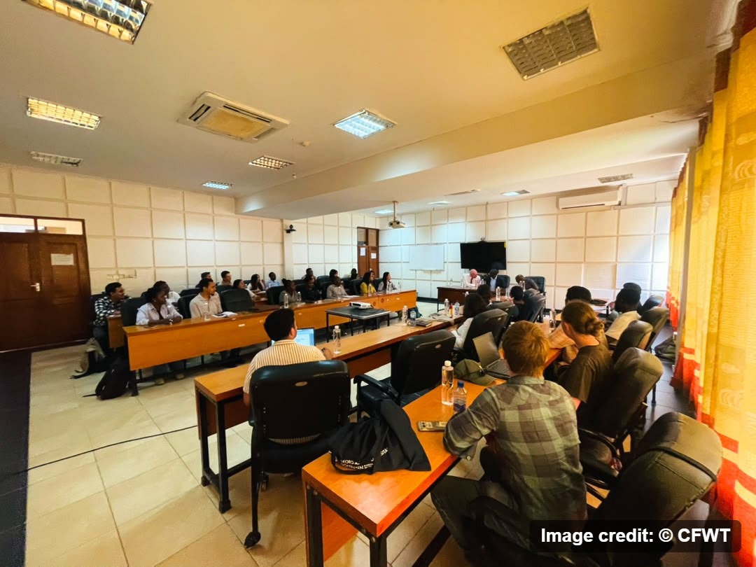 Visiting students and CFWT staff seated around tables in a board room during the introductory meeting