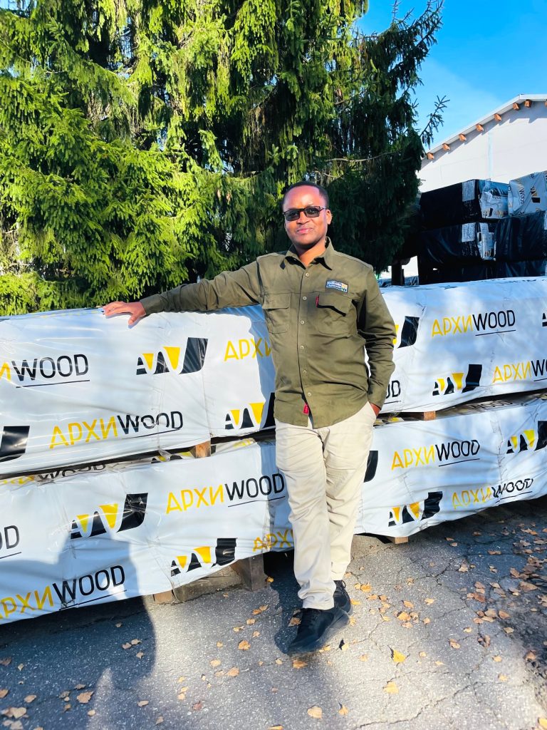 Mr. Gabriel W. Mangi beside packaged wood products